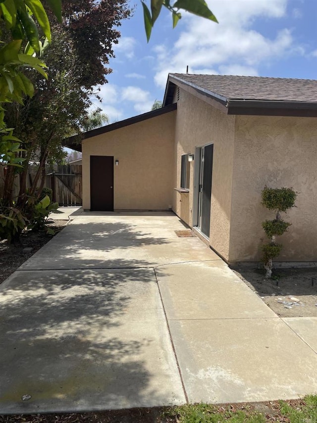 3694 Branch Ct, Oceanside, CA 92058 - view of home's exterior featuring stucco siding, a patio area, and roof with shingles