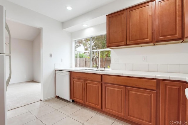 3694 Branch Ct, Oceanside, CA 92058 - kitchen with white appliances, brown cabinetry, light colored carpet, recessed lighting, and light tile patterned flooring