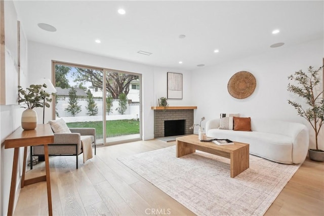 1147 Charleston St, Costa Mesa, CA 92626 - living area with light wood-style flooring, recessed lighting, and a brick fireplace