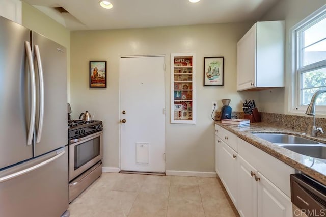 730 S 31st St, San Diego, CA 92113 - kitchen featuring appliances with stainless steel finishes, white cabinets, light stone countertops, recessed lighting, and light tile patterned floors