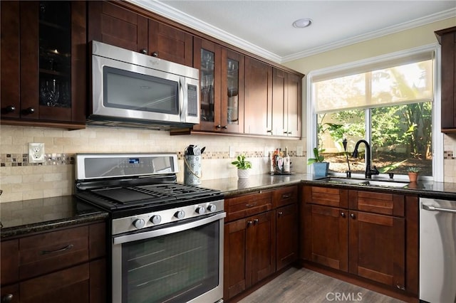 2350 Claudia St, Corona, CA 92882 - kitchen featuring stainless steel appliances, ornamental molding, dark stone countertops, tasteful backsplash, and glass insert cabinets