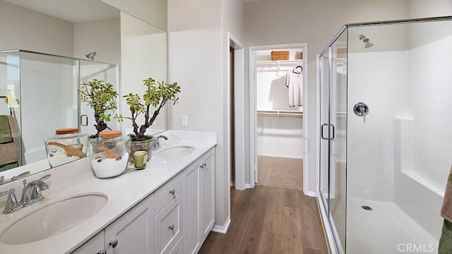 457 Wildrose Cir, San Jacinto, CA 92582 - bathroom featuring a shower stall, double vanity, wood finished floors, and a spacious closet