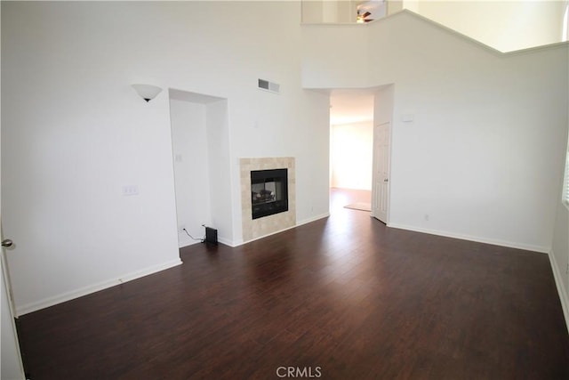 9 Greenwich Ct, Aliso Viejo, CA 92656 - unfurnished living room featuring wood finished floors, a tile fireplace, and a high ceiling