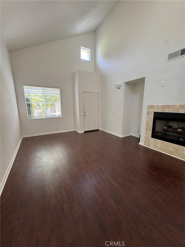9 Greenwich Ct, Aliso Viejo, CA 92656 - unfurnished living room featuring high vaulted ceiling, dark wood-type flooring, healthy amount of natural light, and a tile fireplace