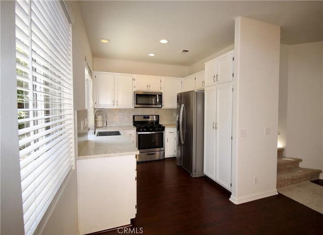9 Greenwich Ct, Aliso Viejo, CA 92656 - kitchen with stainless steel appliances, light countertops, white cabinetry, decorative backsplash, and dark wood-type flooring