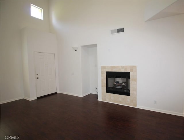 9 Greenwich Ct, Aliso Viejo, CA 92656 - unfurnished living room with wood finished floors, a towering ceiling, and a tiled fireplace