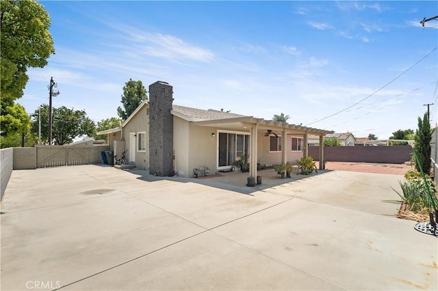 1322 W 6th St, Ontario, CA 91762 - back of house with stucco siding, a gate, a chimney, a patio, and a fenced backyard