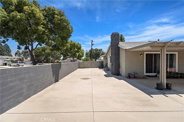 1322 W 6th St, Ontario, CA 91762 - view of side of property with a chimney, stucco siding, a gate, and a patio area