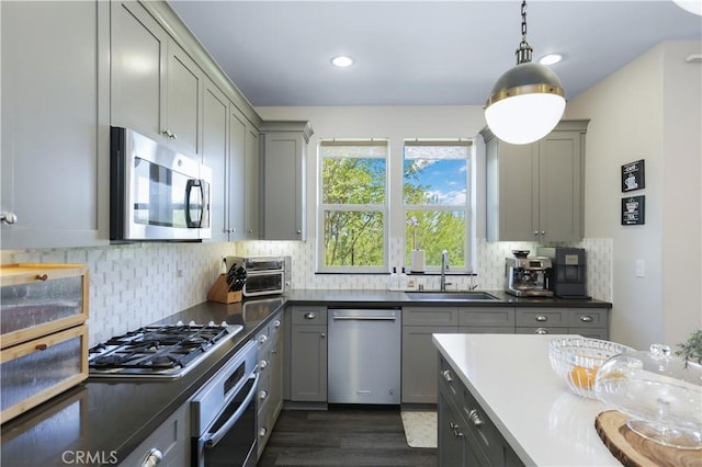 55 Fuchsia, Lake Forest, CA 92630 - kitchen featuring stainless steel appliances, gray cabinetry, dark wood-type flooring, backsplash, and dark countertops