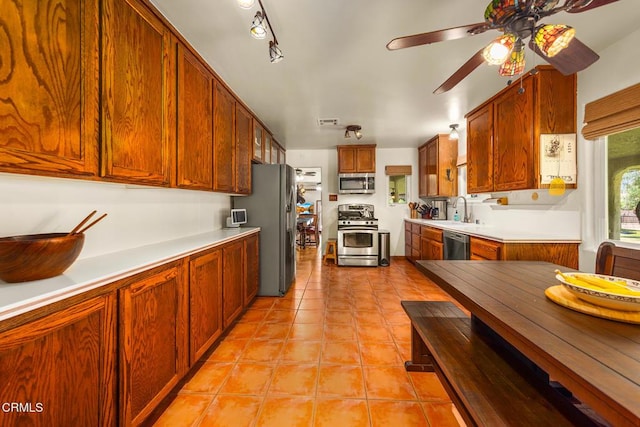 30370 Bouquet Canyon Rd, Santa Clarita, CA 91390 - kitchen with stainless steel appliances, a ceiling fan, light tile patterned floors, light countertops, and brown cabinetry