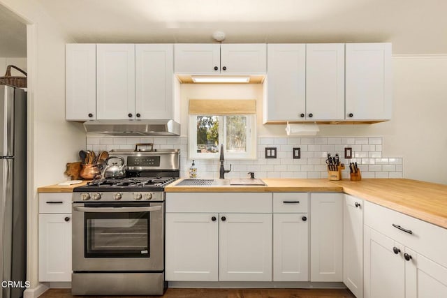 30370 Bouquet Canyon Rd, Santa Clarita, CA 91390 - kitchen with stainless steel appliances, under cabinet range hood, backsplash, and white cabinetry