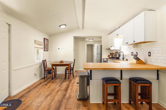 30370 Bouquet Canyon Rd, Santa Clarita, CA 91390 - kitchen featuring butcher block countertops, light wood-style floors, backsplash, and a kitchen breakfast bar
