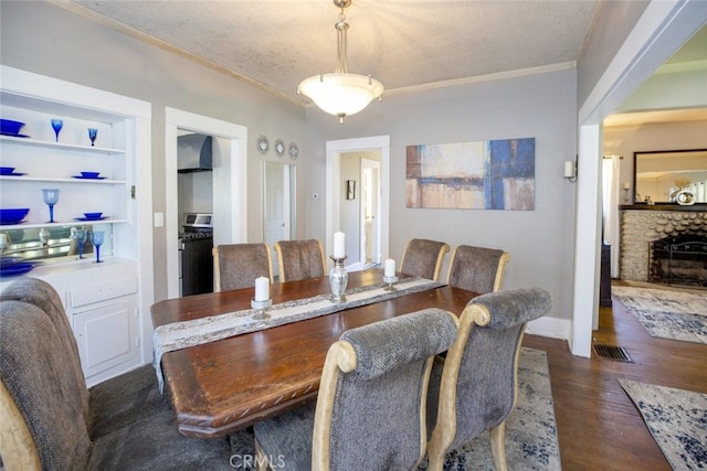 1010 N Madison Ave, Pasadena, CA 91104 - dining area featuring dark wood-style flooring, crown molding, a textured ceiling, and a fireplace