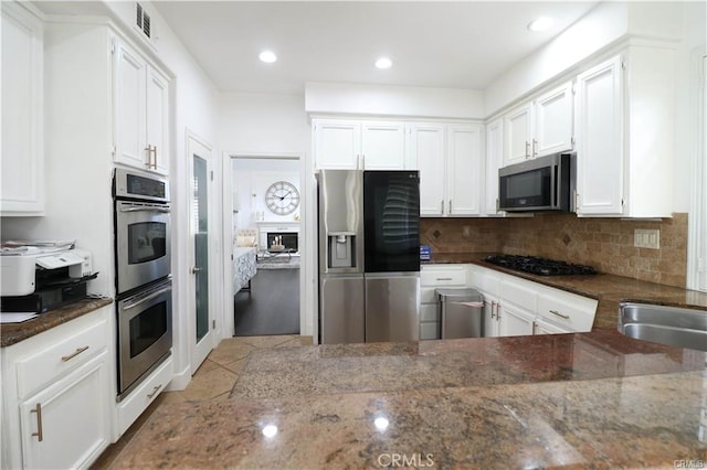 2430 Spring Meadow Dr, Chino Hills, CA 91709 - kitchen with appliances with stainless steel finishes, dark stone countertops, white cabinets, backsplash, and recessed lighting