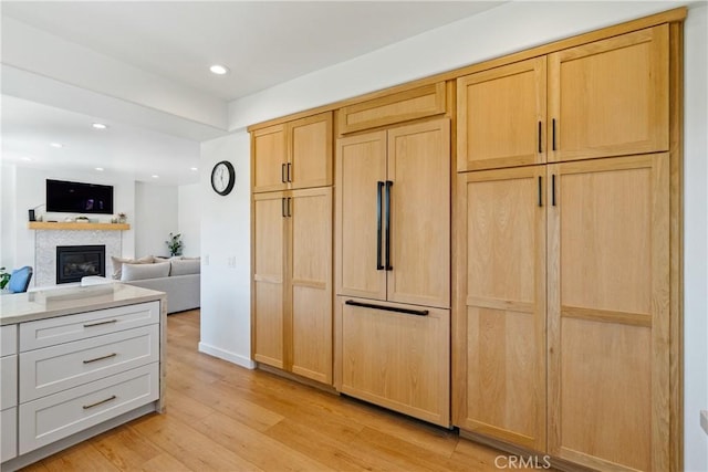 433 Emerald Bay Dr, Arroyo Grande, CA 93420 - kitchen with paneled refrigerator, light wood finished floors, a glass covered fireplace, light countertops, and recessed lighting