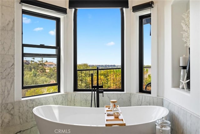 433 Emerald Bay Dr, Arroyo Grande, CA 93420 - bathroom featuring a freestanding bath, tile walls, plenty of natural light, and wainscoting