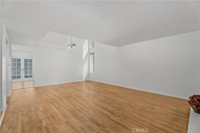 18 Denver Unit 71, Irvine, CA 92604 - empty room with a chandelier, light wood finished floors, and french doors