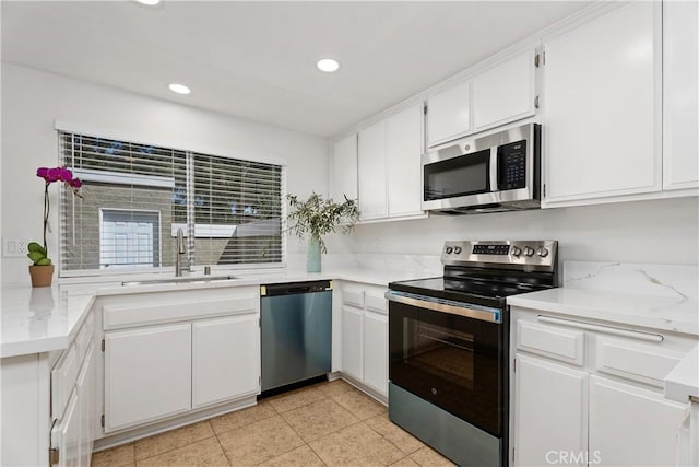 18 Denver Unit 71, Irvine, CA 92604 - kitchen featuring appliances with stainless steel finishes, white cabinets, recessed lighting, light tile patterned flooring, and light stone countertops