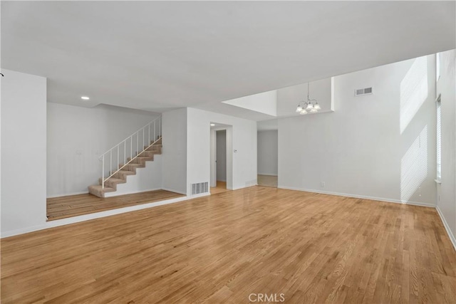 18 Denver Unit 71, Irvine, CA 92604 - unfurnished living room featuring a chandelier, stairway, light wood-style flooring, and recessed lighting