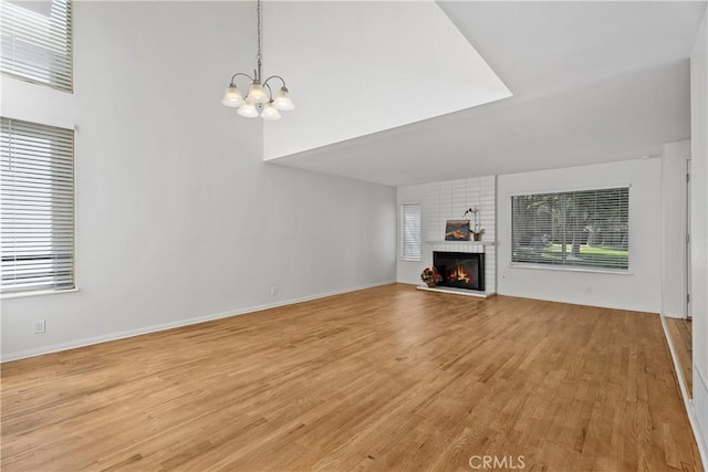 18 Denver Unit 71, Irvine, CA 92604 - unfurnished living room with light wood-type flooring, a chandelier, and a fireplace
