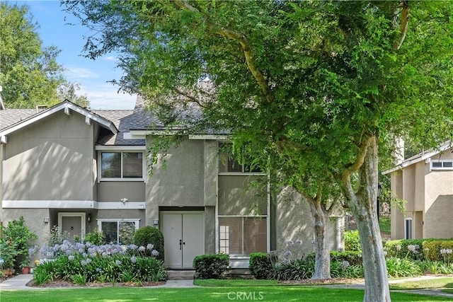 18 Denver Unit 71, Irvine, CA 92604 - townhome / multi-family property featuring stucco siding, roof with shingles, and a front lawn