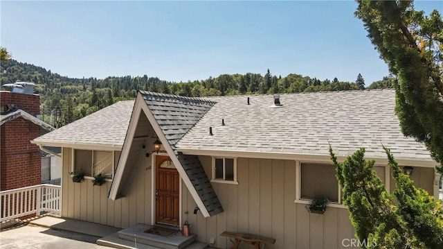 448 Delle Dr, Crestline, CA 92325 - view of front facade with roof with shingles and a view of trees