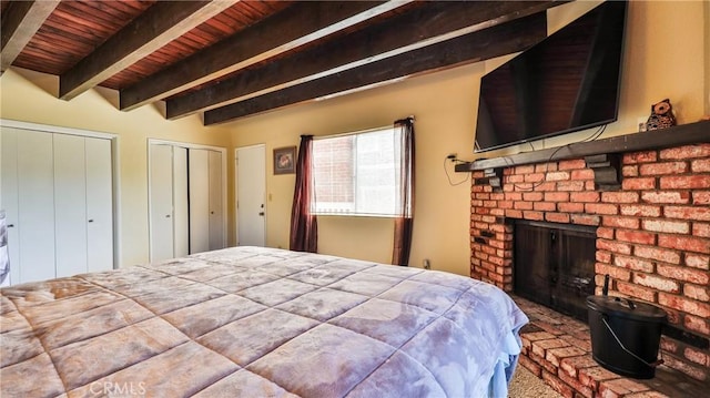 448 Delle Dr, Crestline, CA 92325 - bedroom with a wooden ceiling with exposed beams, a brick fireplace, two closets, and carpet floors