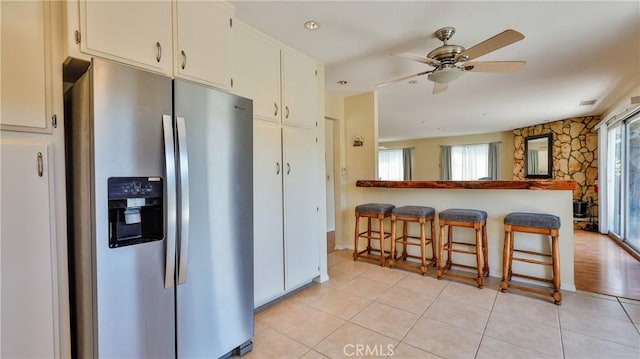 448 Delle Dr, Crestline, CA 92325 - kitchen featuring stainless steel fridge with ice dispenser, a breakfast bar area, light tile patterned flooring, ceiling fan, and a peninsula
