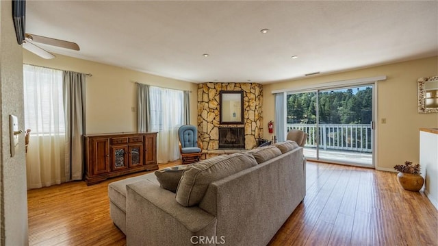 448 Delle Dr, Crestline, CA 92325 - living room with a ceiling fan, wood finished floors, and a stone fireplace