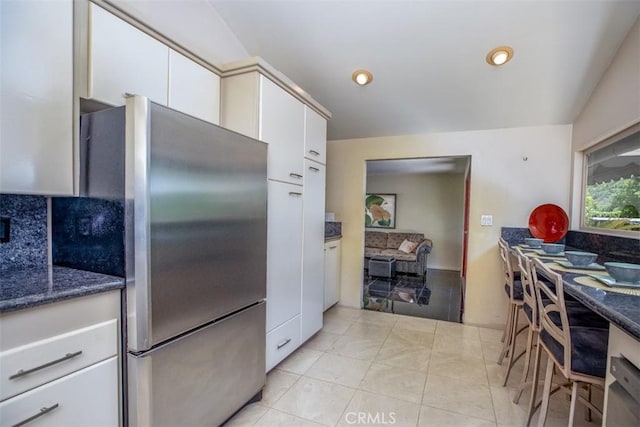 31781 National Park Dr, Laguna Niguel, CA 92677 - kitchen with freestanding refrigerator, white cabinets, backsplash, light tile patterned floors, and dark stone counters