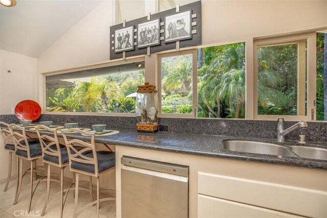 31781 National Park Dr, Laguna Niguel, CA 92677 - kitchen with dishwasher, vaulted ceiling, light tile patterned flooring, and dark stone countertops