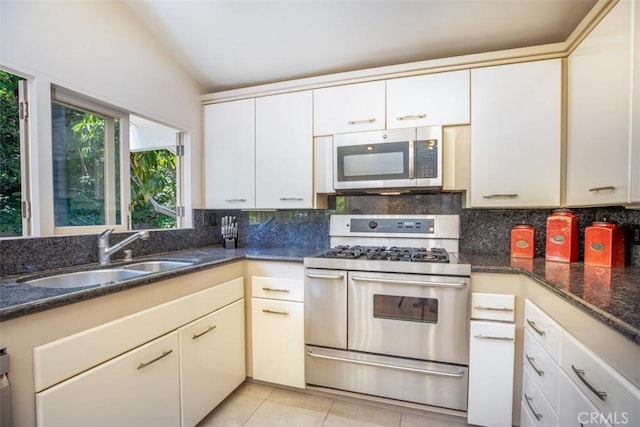 31781 National Park Dr, Laguna Niguel, CA 92677 - kitchen featuring stainless steel appliances, decorative backsplash, dark stone countertops, light tile patterned floors, and lofted ceiling
