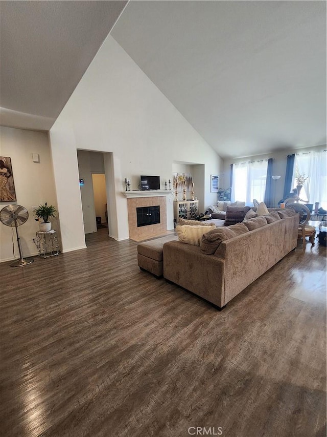 37882 Lopez Ln, Palmdale, CA 93552 - living room with high vaulted ceiling, dark wood-style flooring, and a tile fireplace