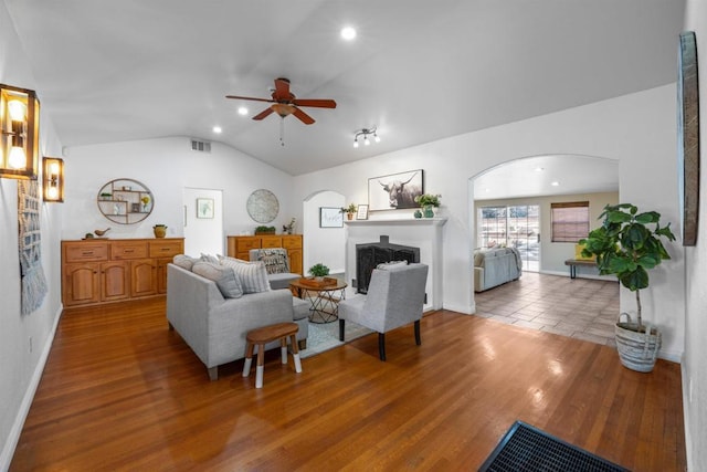 1415 Rex Ln, El Cajon, CA 92021 - living room with a fireplace, arched walkways, a ceiling fan, vaulted ceiling, and wood finished floors