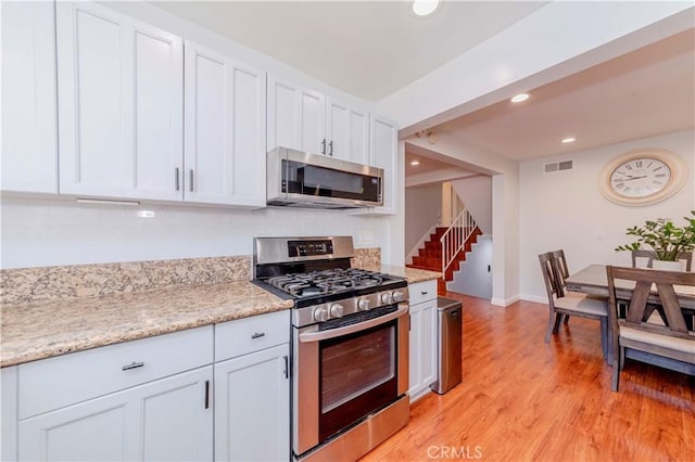 1755 Avenida Selva Unit 60, Fullerton, CA 92833 - kitchen featuring appliances with stainless steel finishes, decorative backsplash, white cabinetry, light wood-type flooring, and recessed lighting