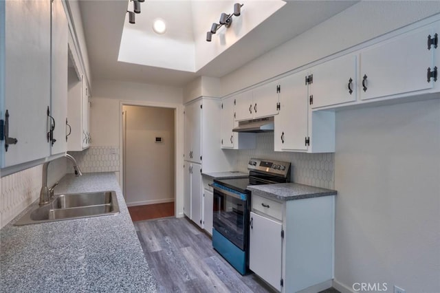 1101 Kensington Dr, Merced, CA 95340 - kitchen featuring stainless steel range with electric cooktop, under cabinet range hood, decorative backsplash, white cabinets, and light wood-style flooring