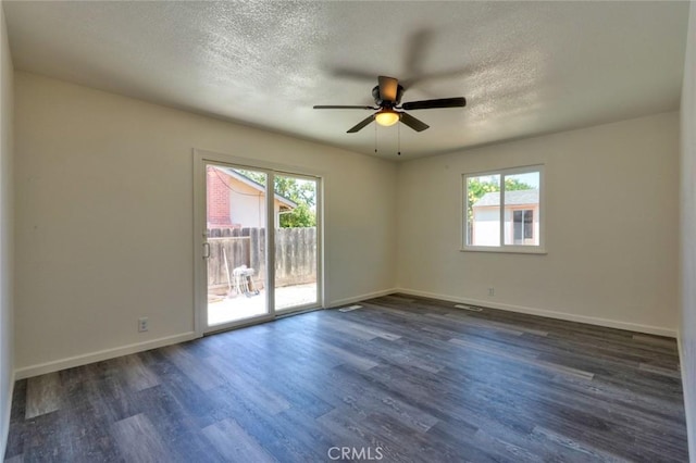 1101 Kensington Dr, Merced, CA 95340 - empty room featuring plenty of natural light, a ceiling fan, dark wood-type flooring, and a textured ceiling