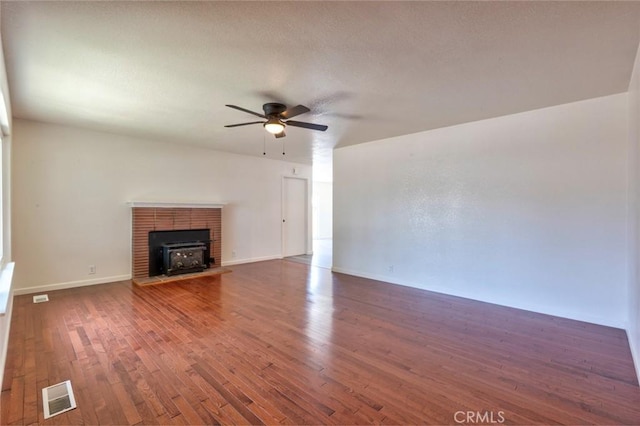 1101 Kensington Dr, Merced, CA 95340 - unfurnished living room with a ceiling fan, wood finished floors, and a wood stove