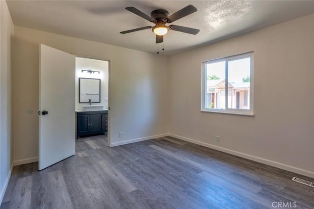 1101 Kensington Dr, Merced, CA 95340 - unfurnished bedroom featuring wood finished floors, ensuite bath, and a ceiling fan