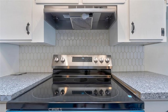 1101 Kensington Dr, Merced, CA 95340 - kitchen with stainless steel electric range, exhaust hood, white cabinetry, and decorative backsplash