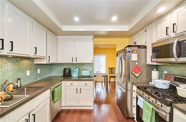 531 Juniper Way, La Habra, CA 90631 - kitchen featuring appliances with stainless steel finishes, a raised ceiling, white cabinets, dark wood-style flooring, and dark countertops