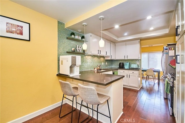 531 Juniper Way, La Habra, CA 90631 - kitchen featuring a peninsula, dark countertops, a tray ceiling, white cabinetry, and dark wood finished floors