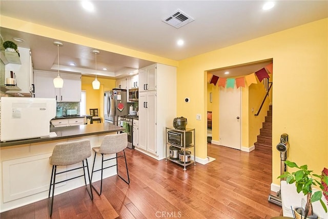 531 Juniper Way, La Habra, CA 90631 - kitchen featuring appliances with stainless steel finishes, dark countertops, a peninsula, dark wood-style flooring, and recessed lighting