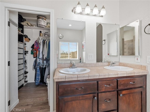 11823 Wintergreen Rd, Pinon Hills, CA 92372 - bathroom featuring double vanity, a spacious closet, and wood finished floors