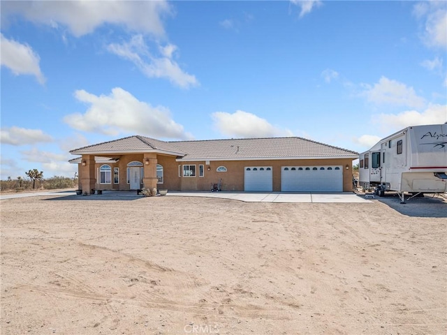 11823 Wintergreen Rd, Pinon Hills, CA 92372 - view of front of home featuring a tile roof, driveway, stucco siding, and an attached garage