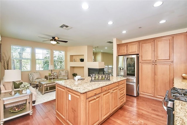 1180 Cornwell Dr, Fullerton, CA 92833 - kitchen featuring stainless steel appliances, ceiling fan, light wood-style flooring, a center island, and a fireplace