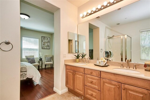 1180 Cornwell Dr, Fullerton, CA 92833 - bathroom featuring a stall shower, double vanity, plenty of natural light, and wood finished floors