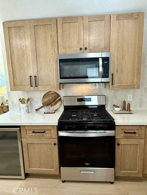 11117 Maidstone Ave, Norwalk, CA 90650 - kitchen featuring stainless steel appliances, beverage cooler, light countertops, and decorative backsplash