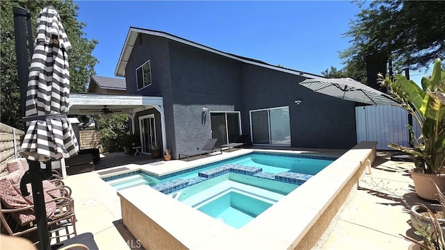8467 Penfield Ave, Winnetka, CA 91306 - rear view of house featuring stucco siding, a patio, a pool with connected hot tub, and ceiling fan