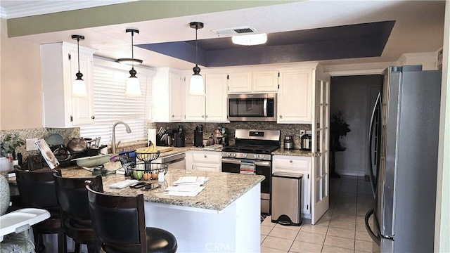 8467 Penfield Ave, Winnetka, CA 91306 - kitchen featuring appliances with stainless steel finishes, a peninsula, backsplash, light tile patterned floors, and white cabinets